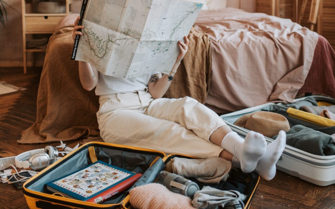 Girl reading map as she packs her bag for her trip to the Pacific Coast